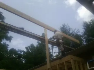 Carpenter setting a ridge beam over a new addition frame — Ice Dam Removal by Roofing Brothers in Crompond