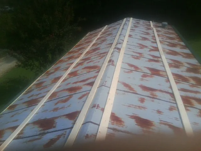 Rusted metal roof panels with new wood purlins before replacement — Storm Damage Roof Repair in Crompond by Roofing Brothers