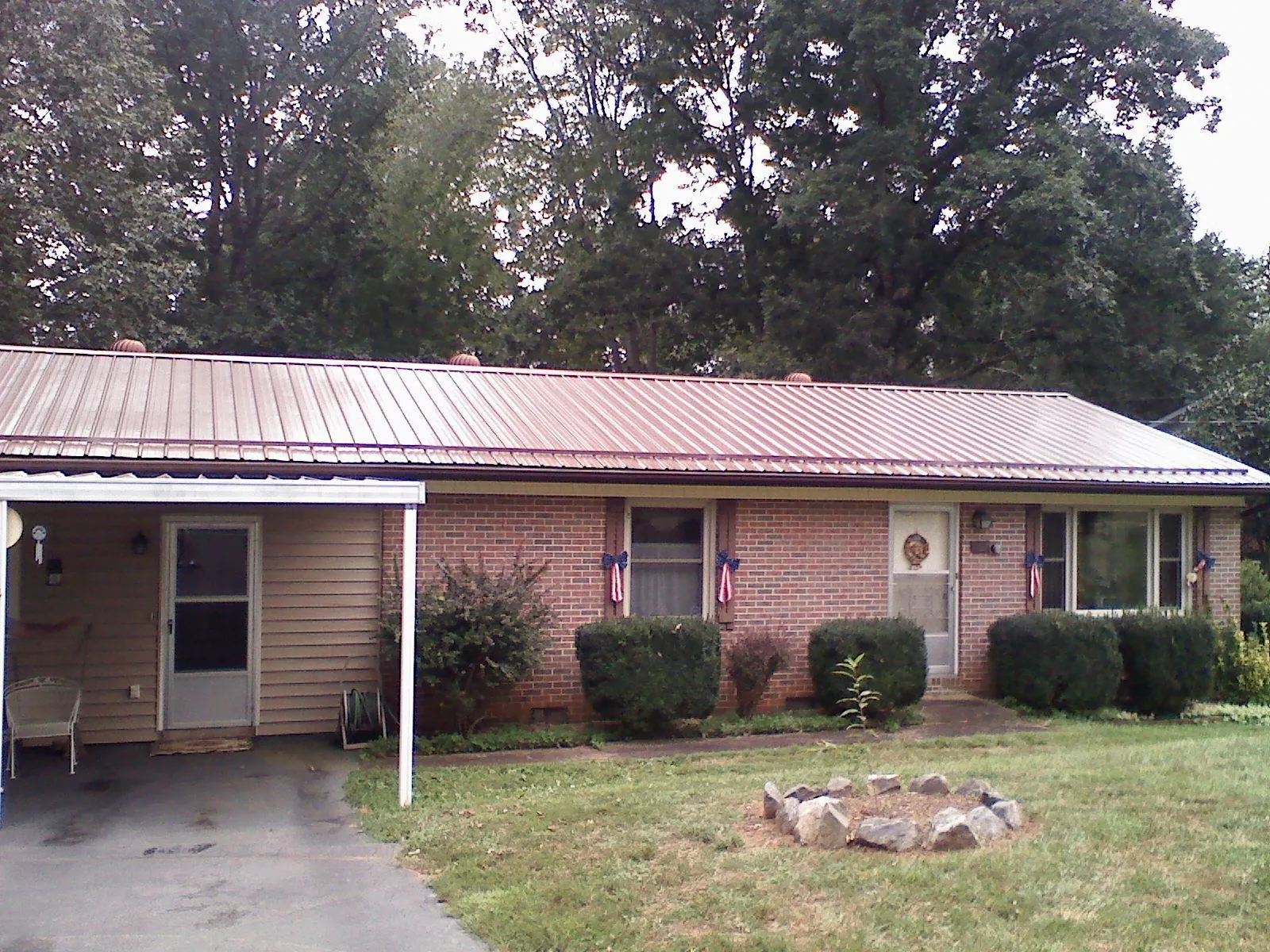 Bronze metal roof and carport on a brick ranch home — Roof Repair work by our crew in Crompond